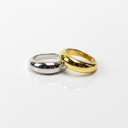 Two wedding rings, one gold and one silver, on a white background