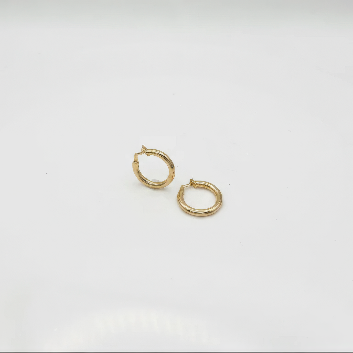 Gold hoop earrings on a light gray background