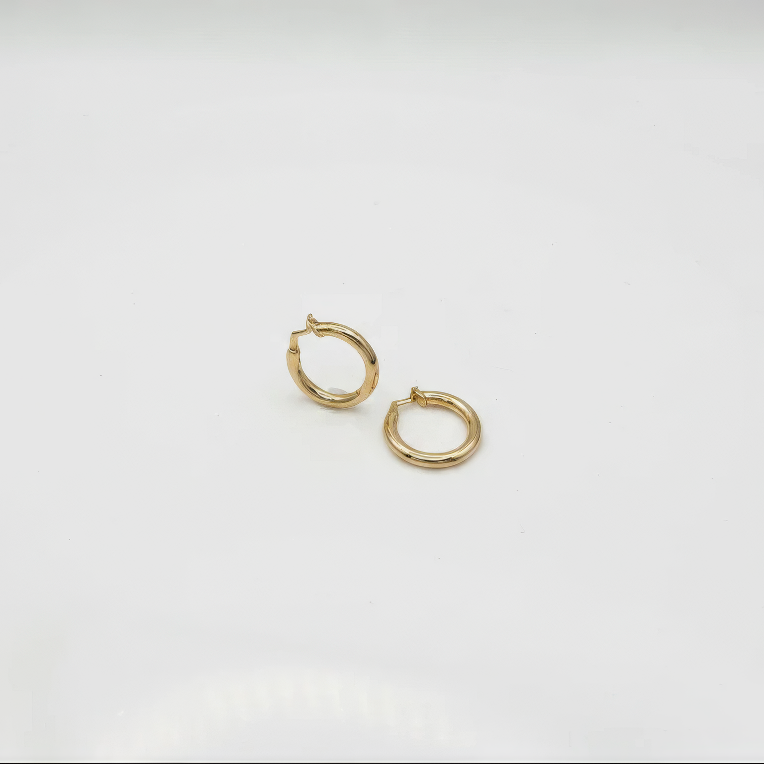 Gold hoop earrings on a light gray background