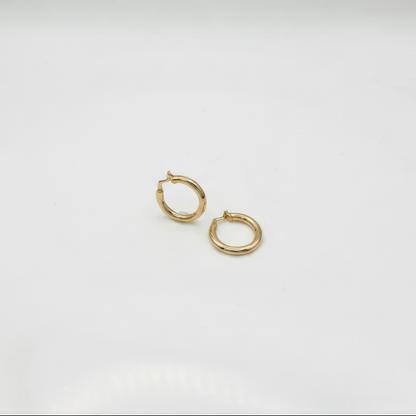 Gold hoop earrings on a light gray background