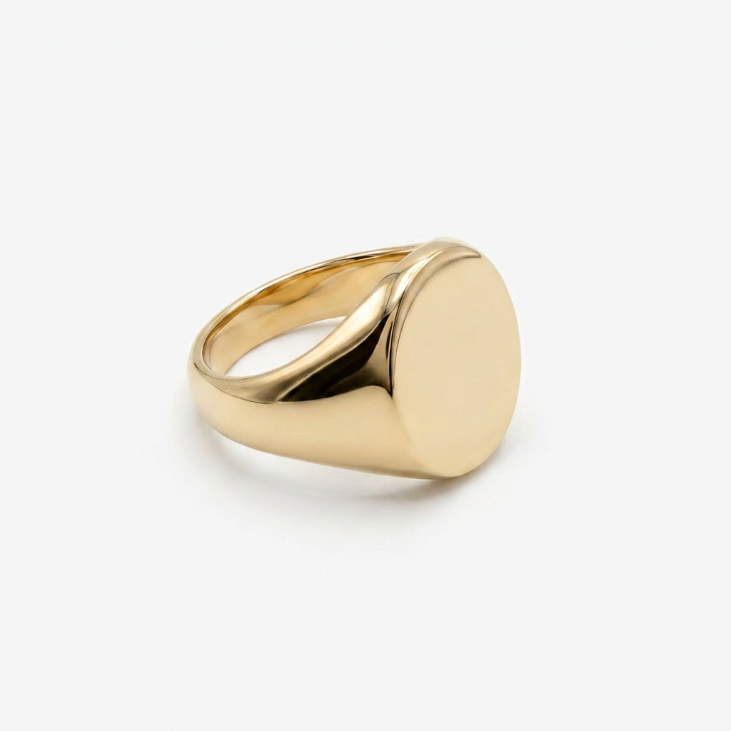 Gold oval signet ring on a white background