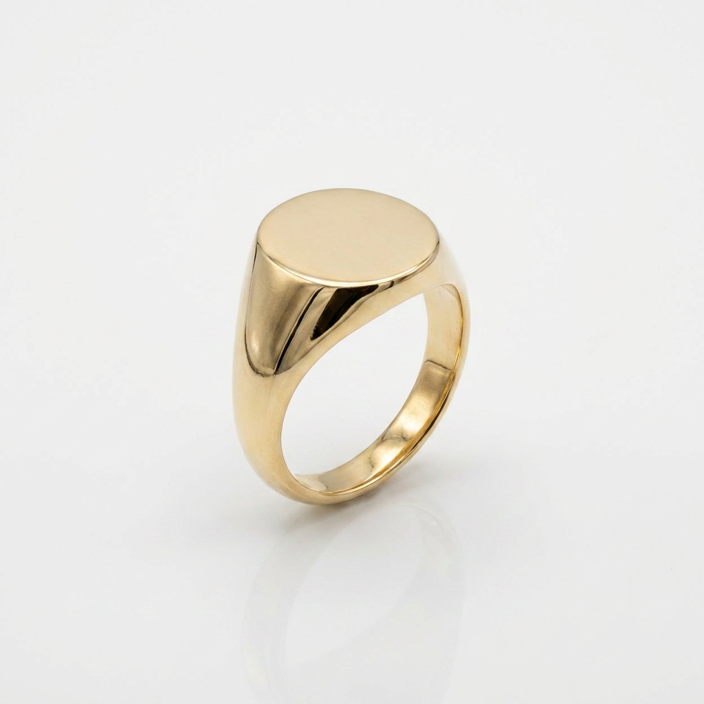 Gold signet ring with a flat, polished top on a light gray background