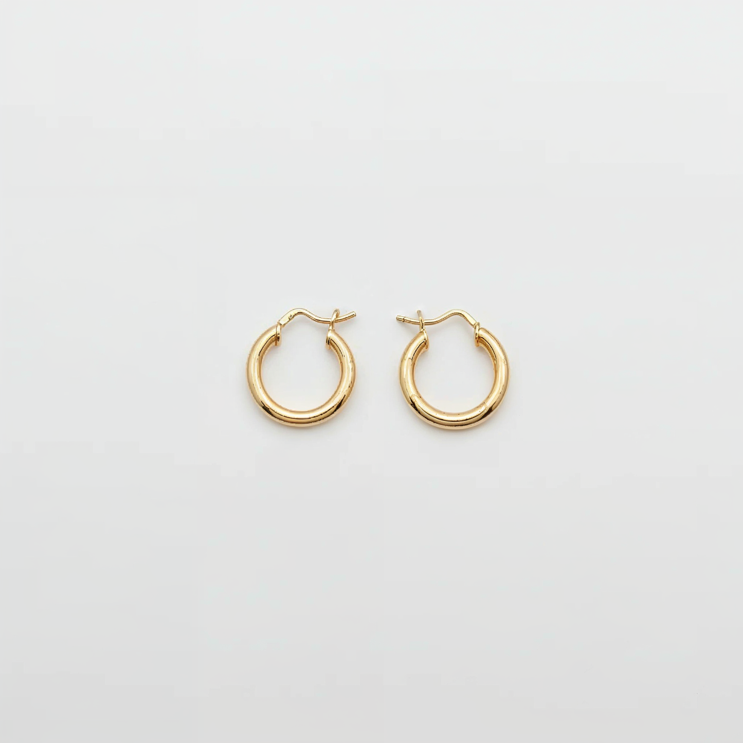 Gold hoop earrings on a light gray background