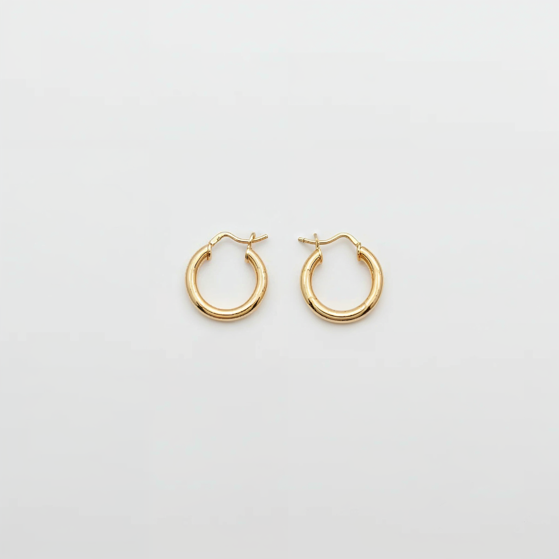 Gold hoop earrings on a light gray background