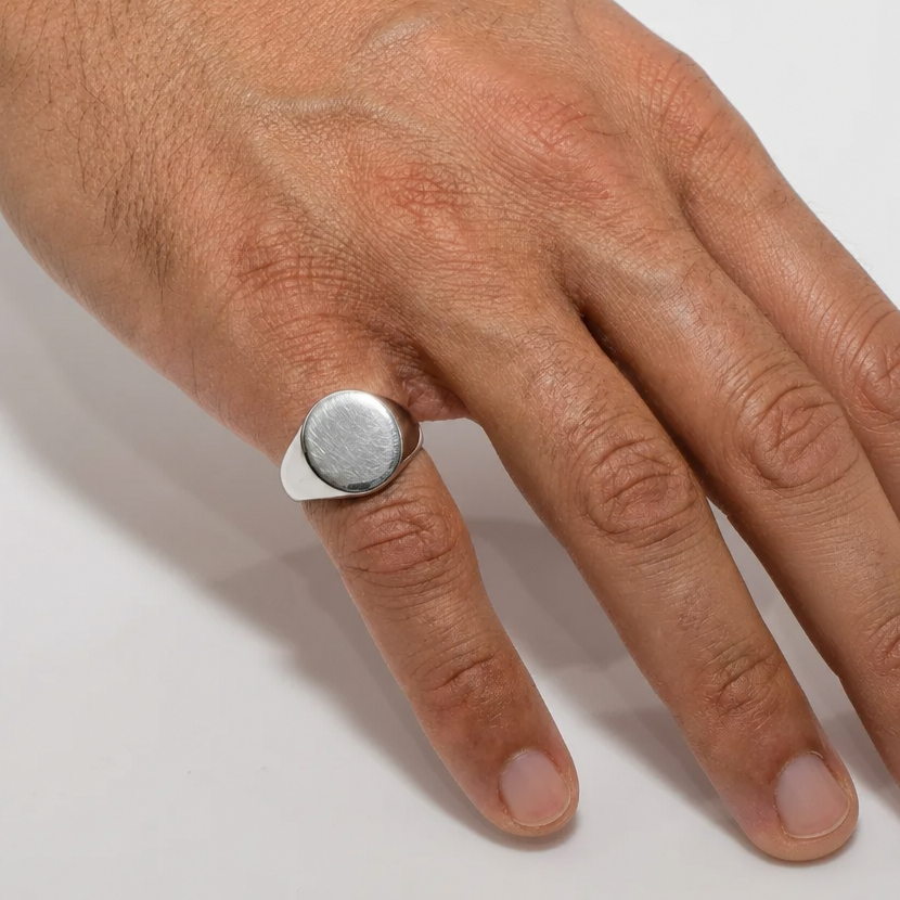 Hand wearing a silver ring on a white background